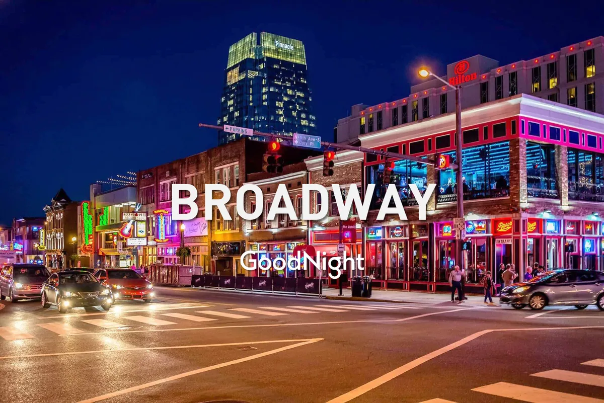 A dynamic nighttime street scene featuring neon signs, a busy thoroughfare filled with people, and high-rise buildings—a quintessential snapshot of Nashville’s Broadway nightlife. The festive mood, bright lights, and activity highlight the area's appeal for nightlife and entertainment.
