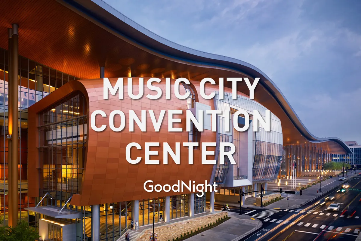 The image showcases the Music City Convention Center's curved architectural design, expansive glass windows, and bright signage, bustling with people attending a major event. The vibrant atmosphere captures the energy of Nashville’s business and conference scene.