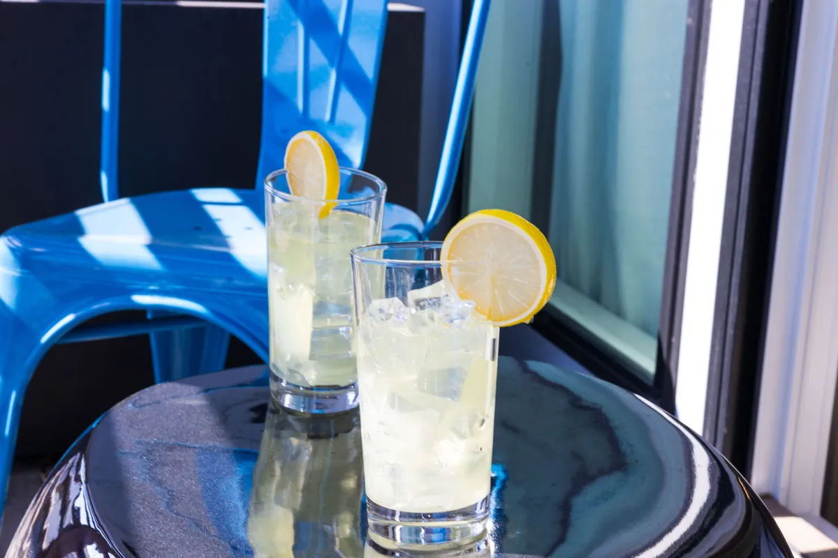 This image features two cocktails on a glossy table, with a blue chair and outdoor setting, suggesting relaxation after a productive day. The inviting and cheerful atmosphere offers a taste of Nashville’s social scene, perfect for unwinding or networking at local eateries.
